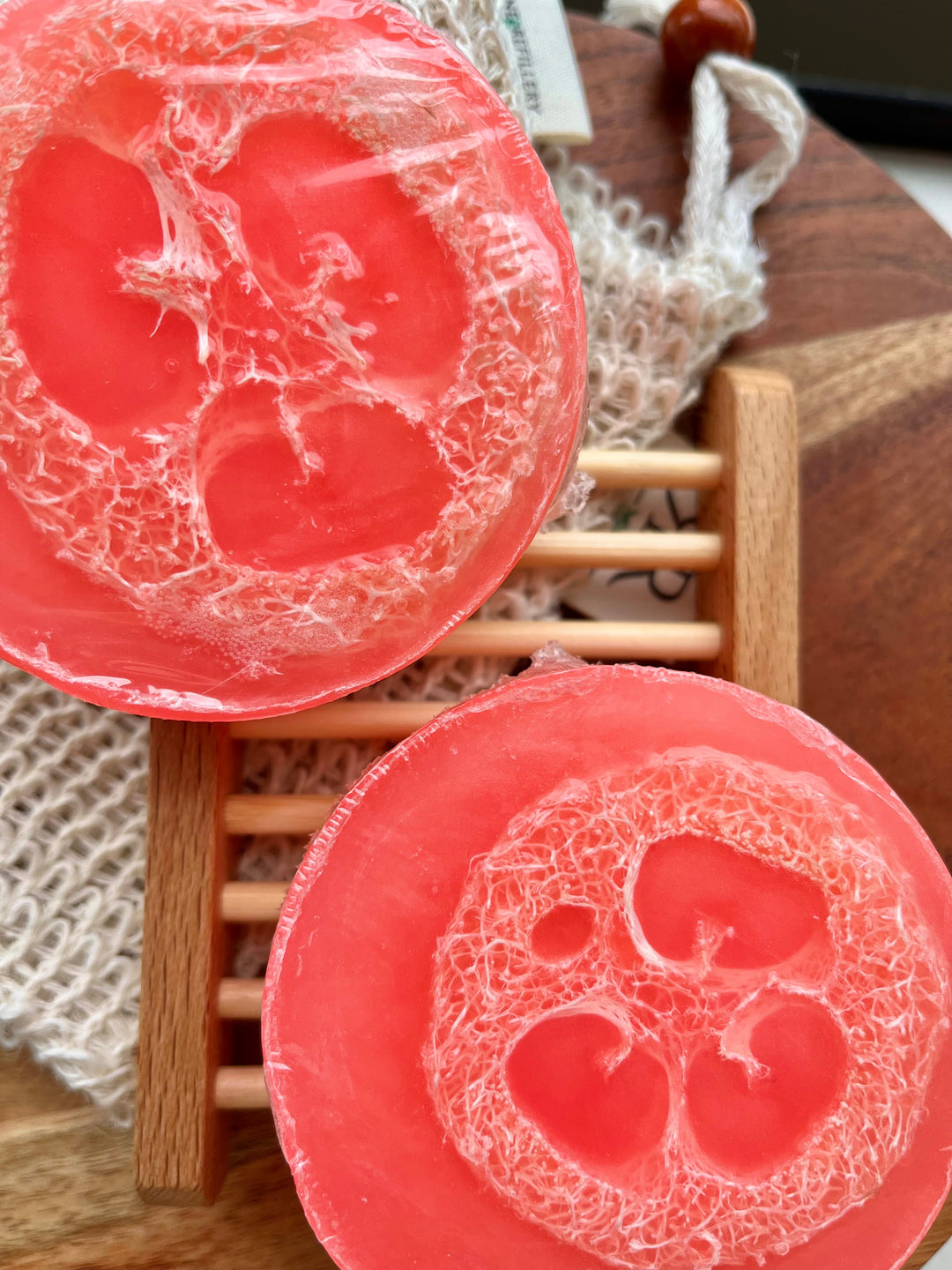 Peach-colored loofah soap bar, showing textured cut surface with swirl pattern