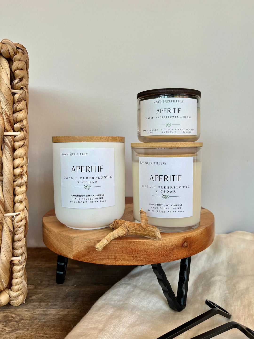 White coconut soy candle jar with wooden lid and printed label, on wooden tray