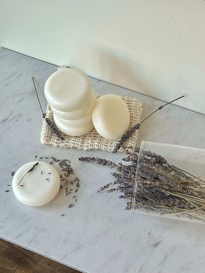 Solid conditioner bar set with stacked white rounds and two flat disks on a cloth