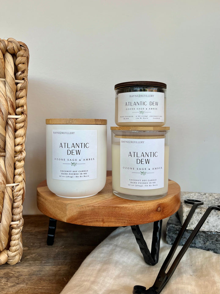 Coconut soy wax candles in white jars with wooden lids, on a wooden stand