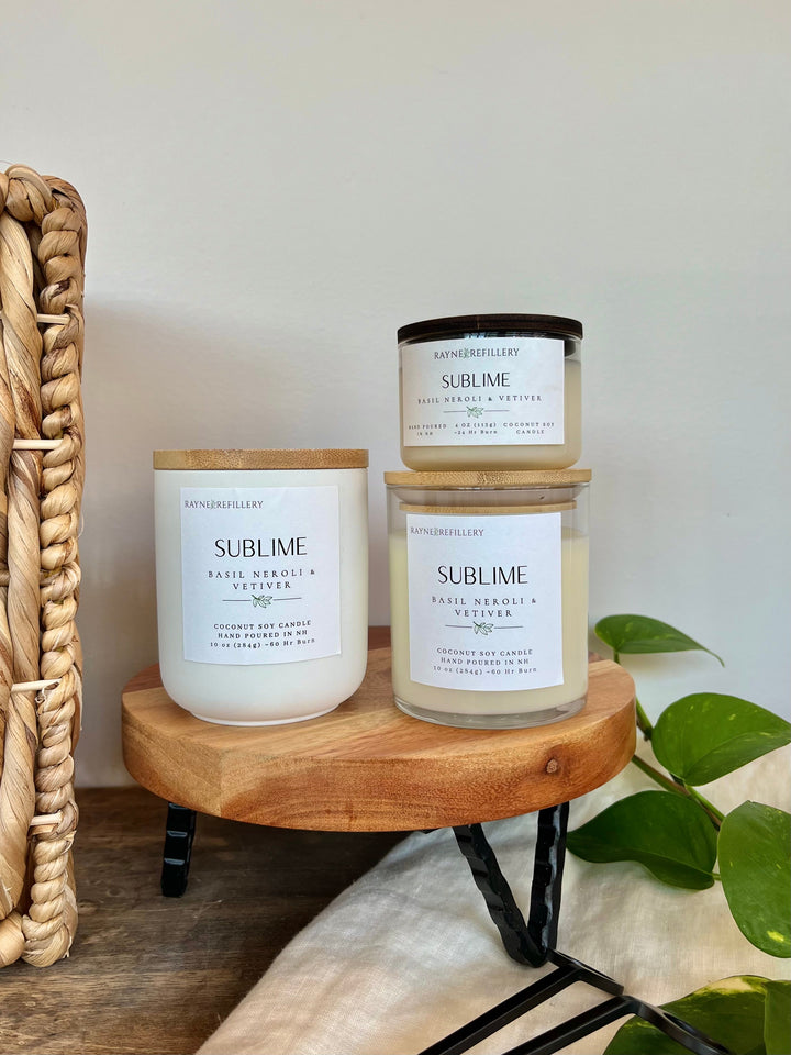 Coconut soy candle set in white glass jars with wood lids on wooden tray