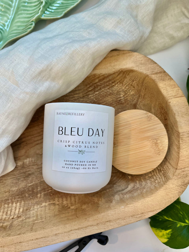 Coconut soy candle in white glass jar with bamboo-style wood lid on oval wooden tray
