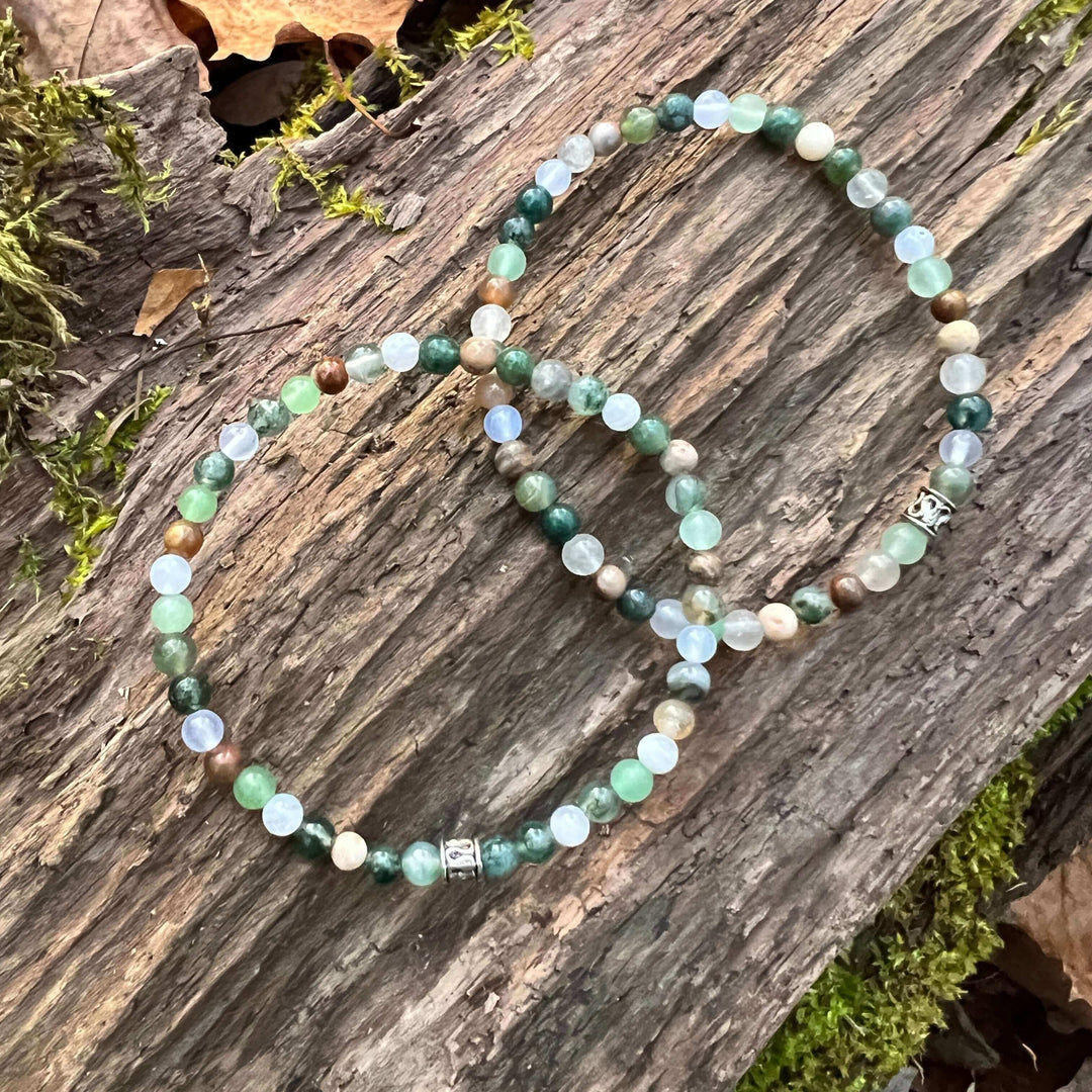 Mini beaded bracelet with mixed green and light blue beads and a silver clasp charm.