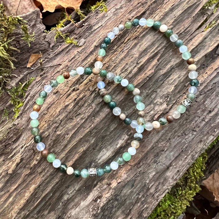 Mini beaded bracelet with mixed green and light blue beads and a silver clasp charm.