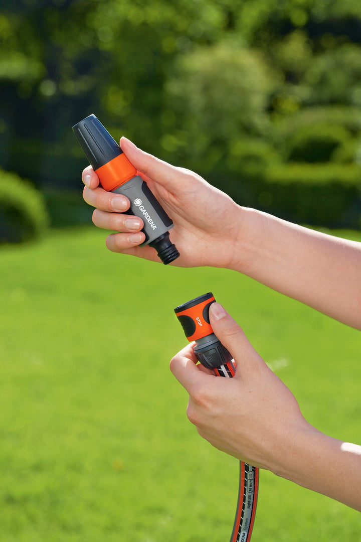 Orange and black water stop hose connector used by hand on a garden hose