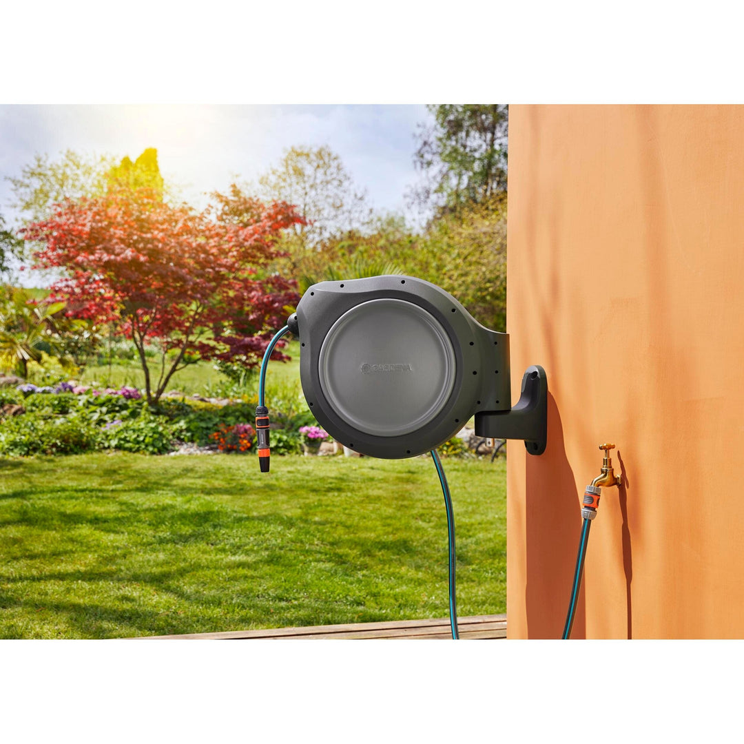 Outdoor wall hose reel, dark gray circular unit with blue hose and orange sprayer