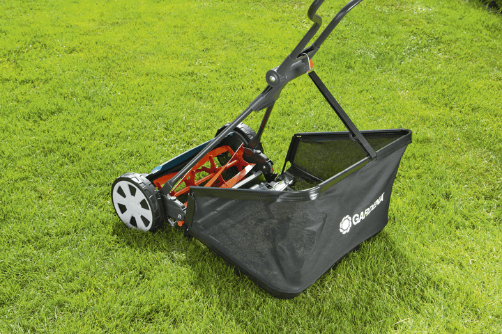 Black grass catcher bag on a push mower with open collection compartment.