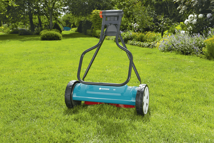 Teal and gray cylinder lawnmower with tall handle and front roller wheels.