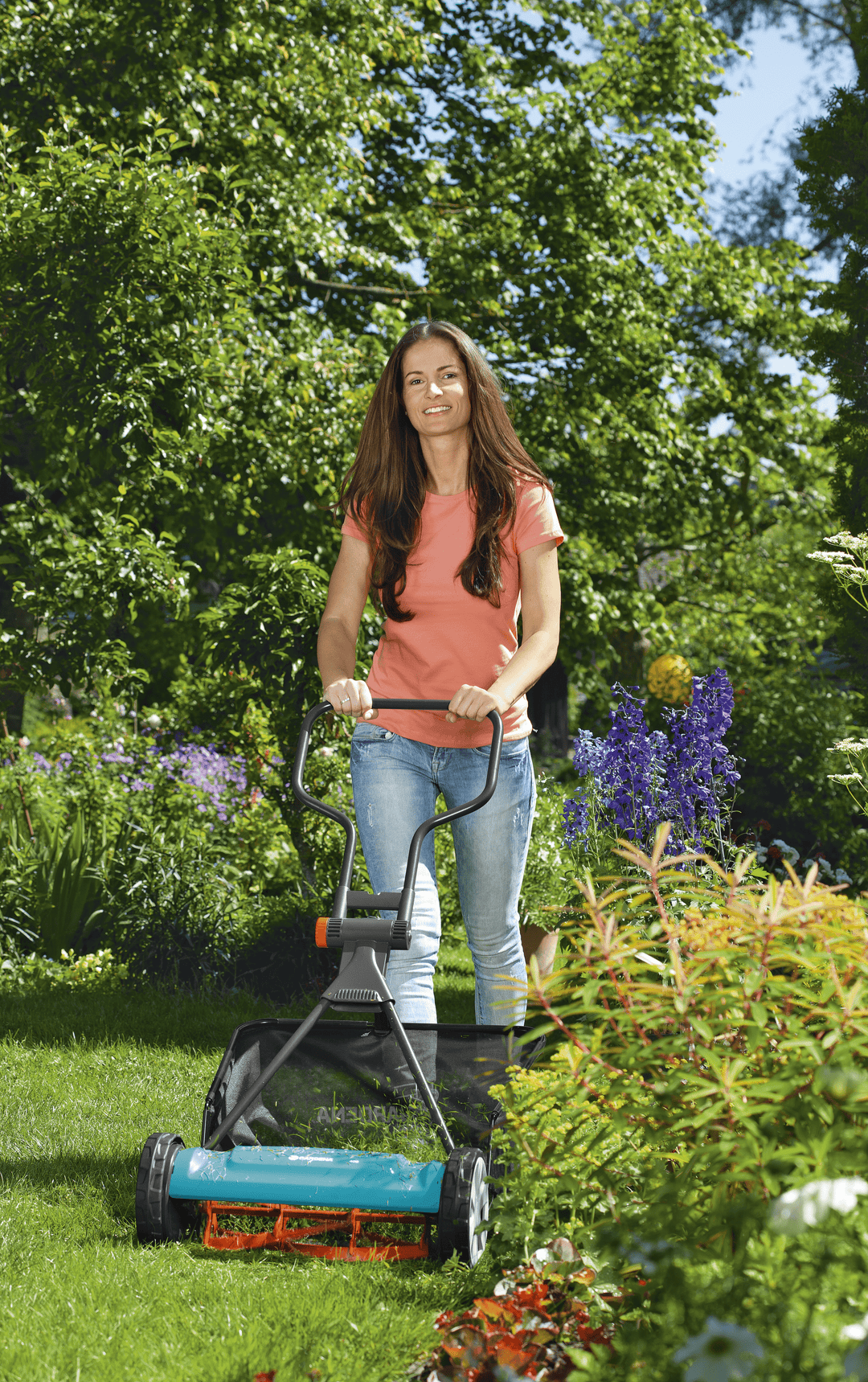 Black grass catcher bag attached to a lawn mower while mowing on grass.
