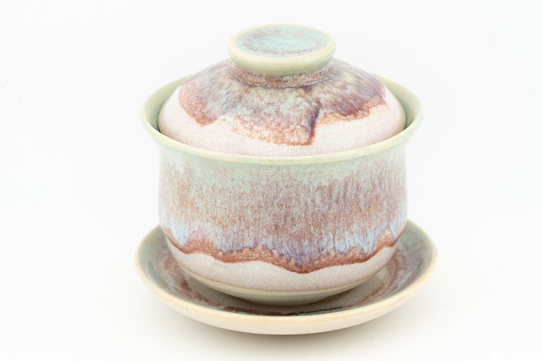 Ceramic gaiwan with multicolor glaze (teal, orange, brown) and matching saucer.