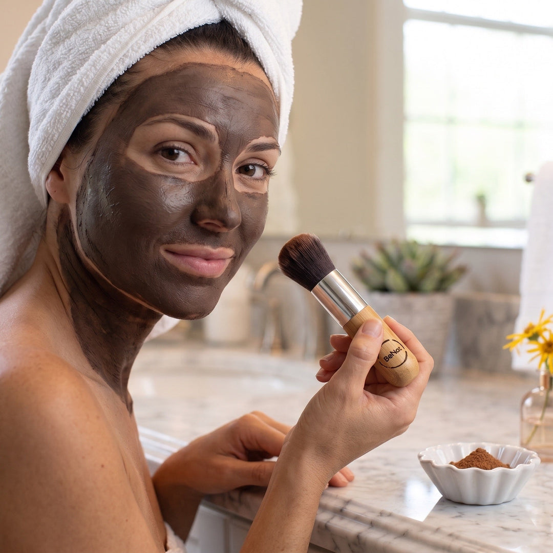 Mud and arnica mask applied to face, beauty brush held near cheek
