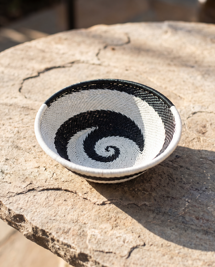 Small woven wire basket bowl with black-and-white spiral pattern and white rim