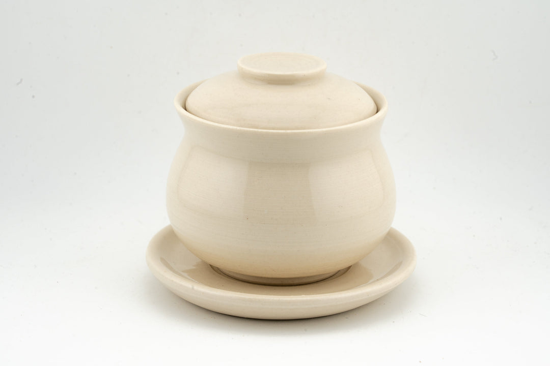 Cream white glazed gaiwan with lid and matching saucer, simple smooth finish.