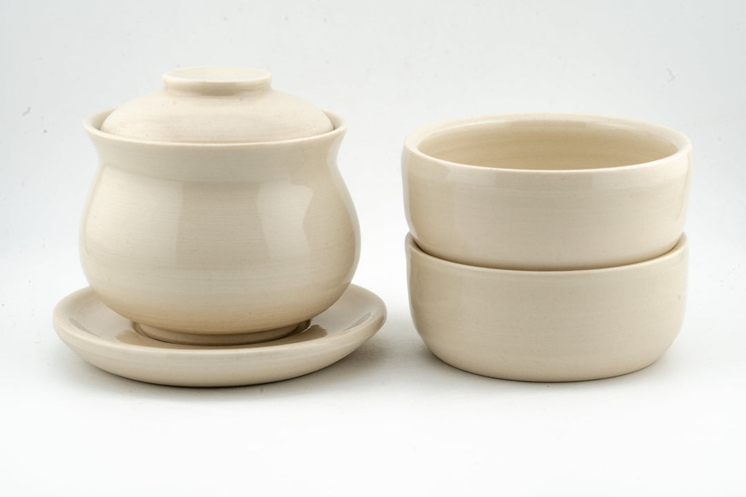Cream white gaiwan with lid and two matching cups, smooth matte-gloss ceramic.