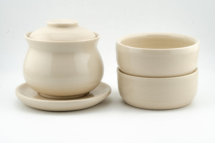 Cream white gaiwan with lid and two matching cups, smooth matte-gloss ceramic.