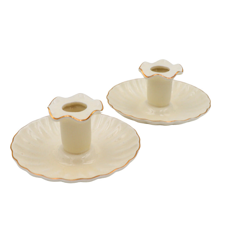Pair of cream ceramic candle holders with scalloped rims and gold-tone accents