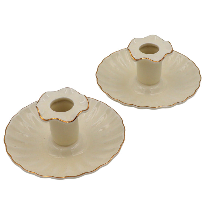 Pair of cream ceramic candle holders with scalloped rims and gold-tone accents