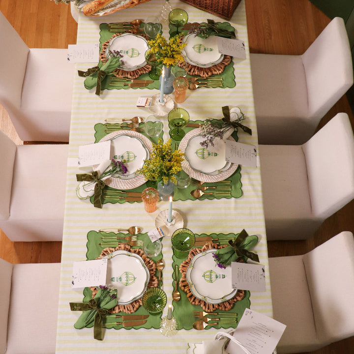Multiple cream ceramic candle holders with scalloped bases and gold-tone accents