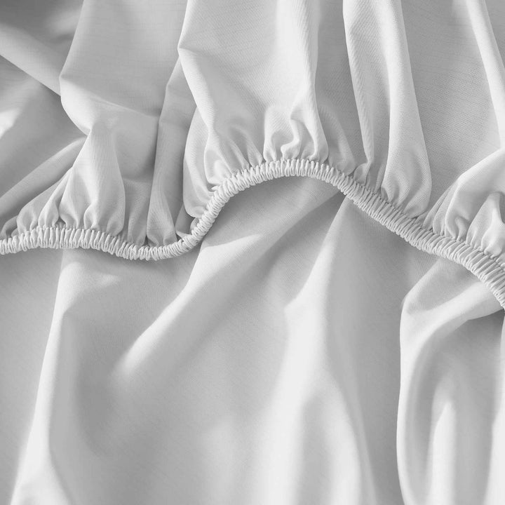 White sheet edge with elasticized, gathered hem for a secure fit