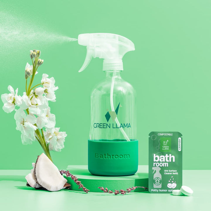 Bathroom glass spray bottle with Green Llama label, white trigger sprayer in green holder