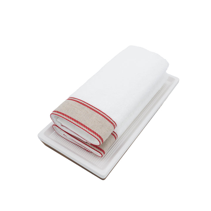 Folded white guest towels with red chain-style linen border
