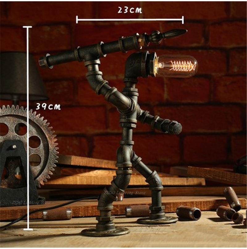 Industrial steampunk style table lamp with glowing Edison bulb and dark metal pipe frame