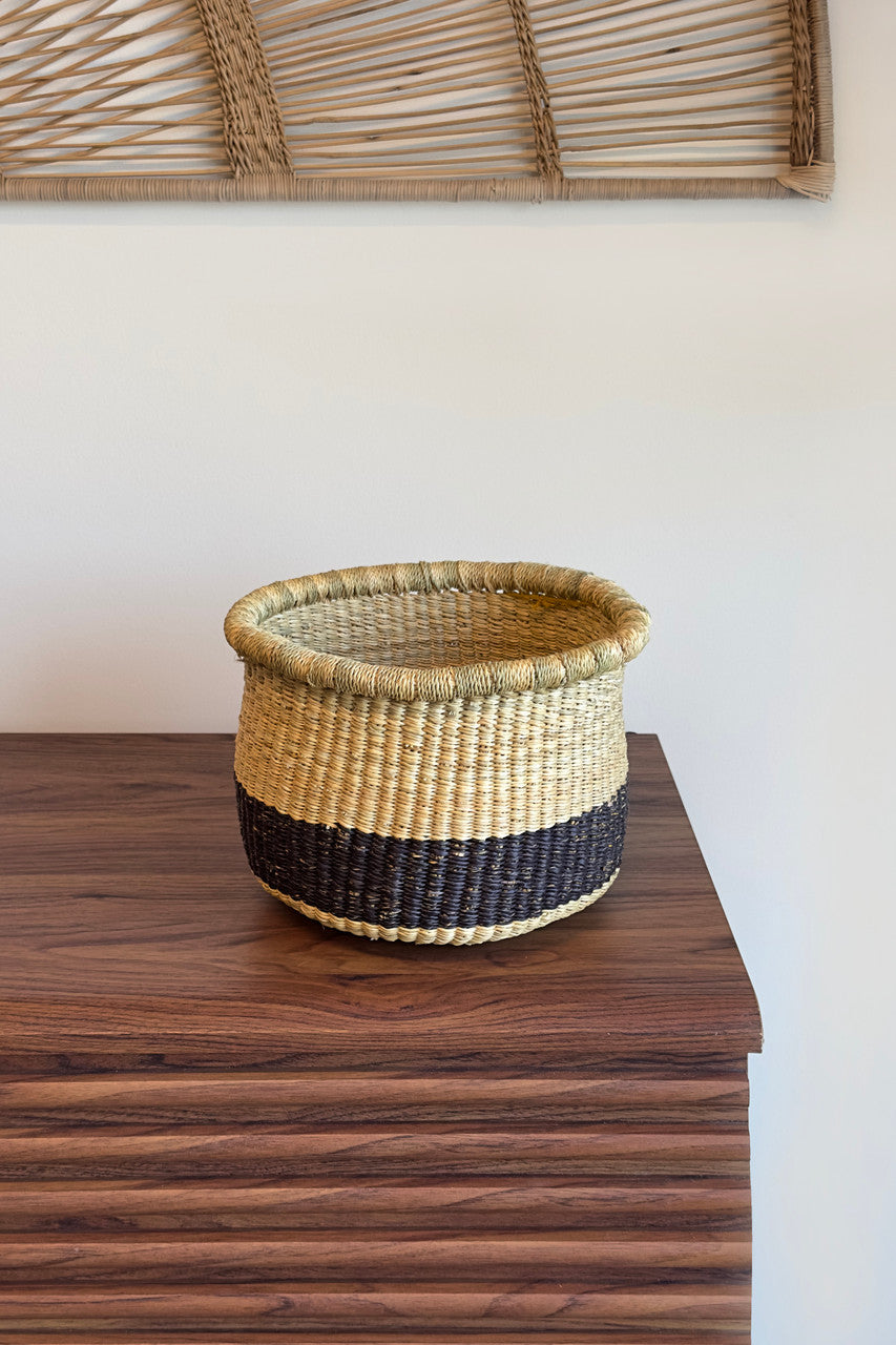 Round woven planter pot with light beige upper section and dark navy-black base band