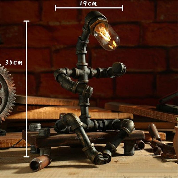 Bronze steampunk table lamp with glowing bulb, curved arm, and multi-tube iron base.