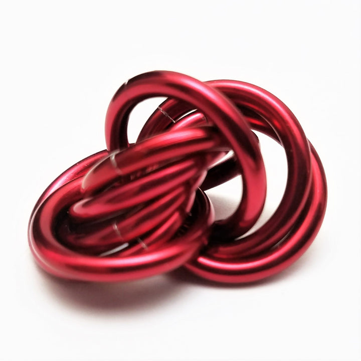 Red metallic stress ball fidget toy with twisted looped cords ball shape.