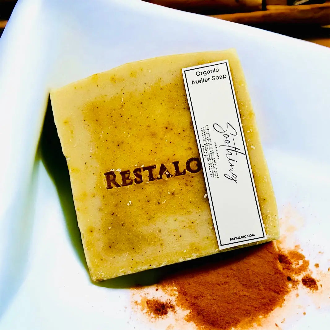 Handcrafted natural soap bar, pale yellow with specks and a rectangular white product label