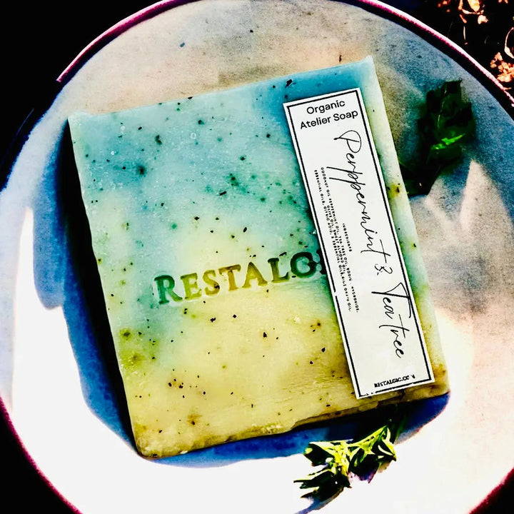 Handcrafted natural soap bar, blue-green and yellow swirls with a white rectangular product label