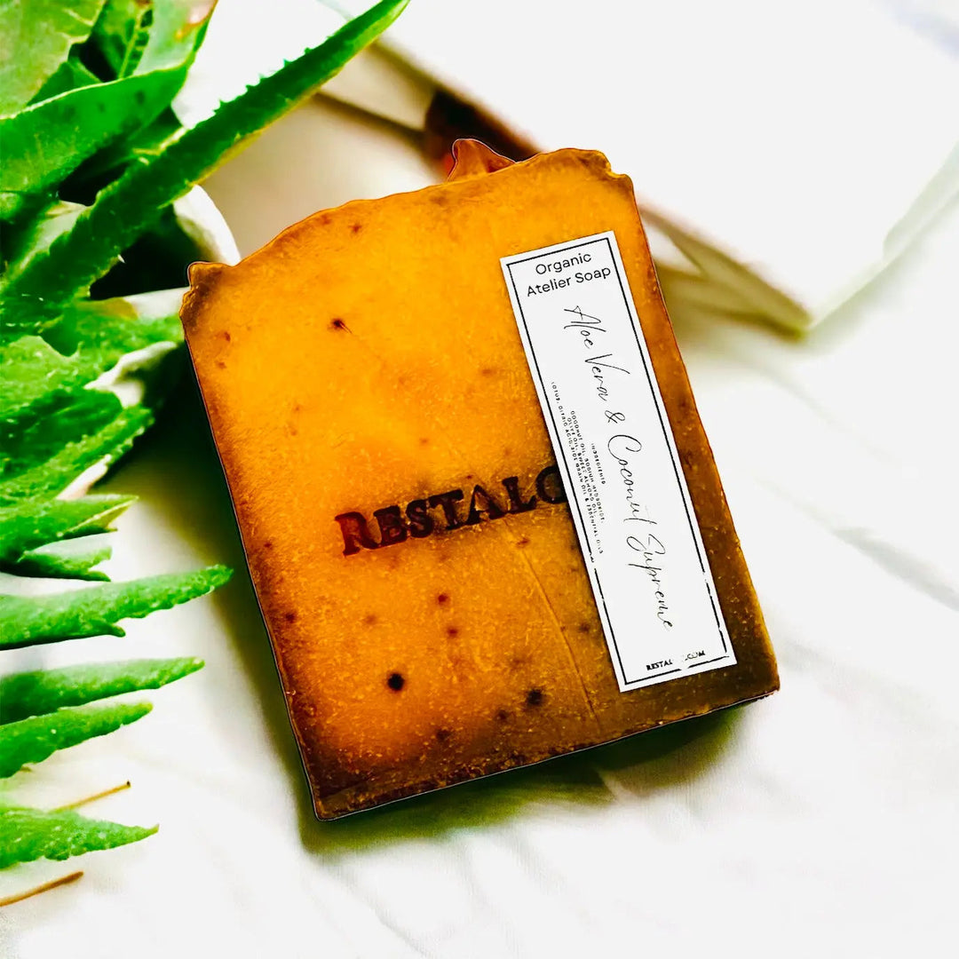 Handcrafted natural soap bar, warm orange with small dark flecks and a rectangular white product label