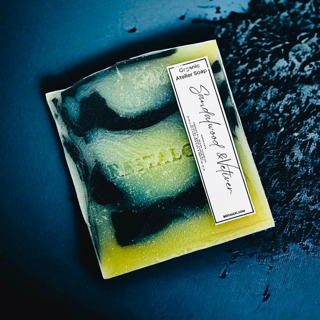 Handcrafted natural soap bar, dark teal and green with speckles and a rectangular white product label