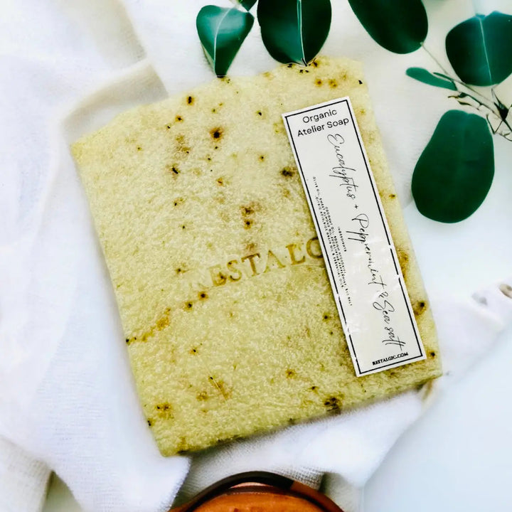 Handcrafted natural soap bar, light yellow with small dark specks and a white rectangular product label
