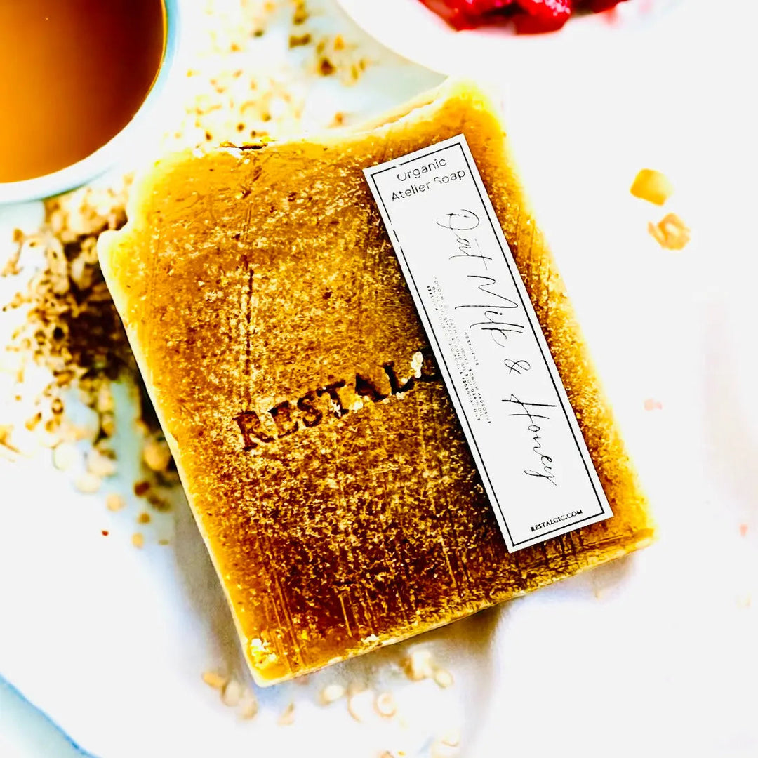 Gold handcrafted natural soap bar with organic Atelier Soap label and dusting.