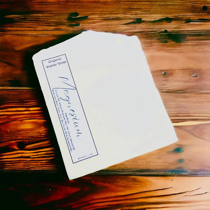 White handcrafted natural soap bar with organic Atelier Soap label.