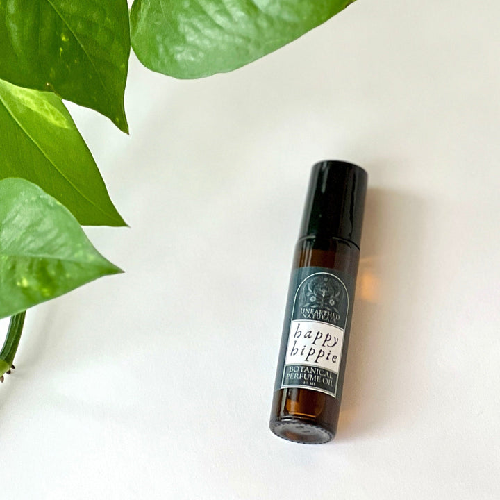Botanical perfume oil bottle with amber liquid and black cap