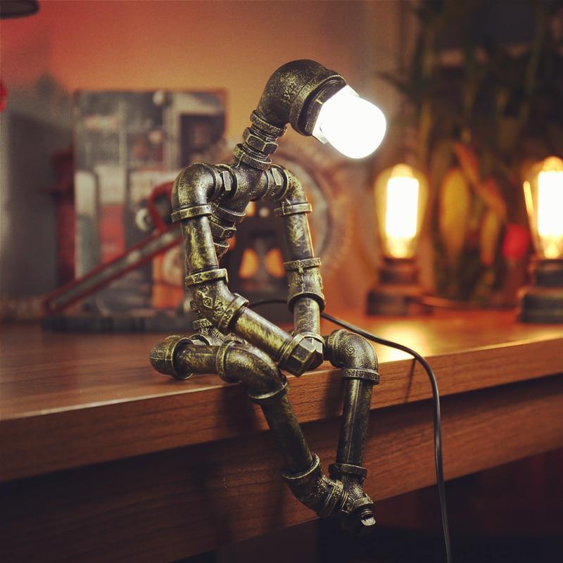Bronze steampunk pipe table lamp with glowing Edison-style bulb and bent tube base.