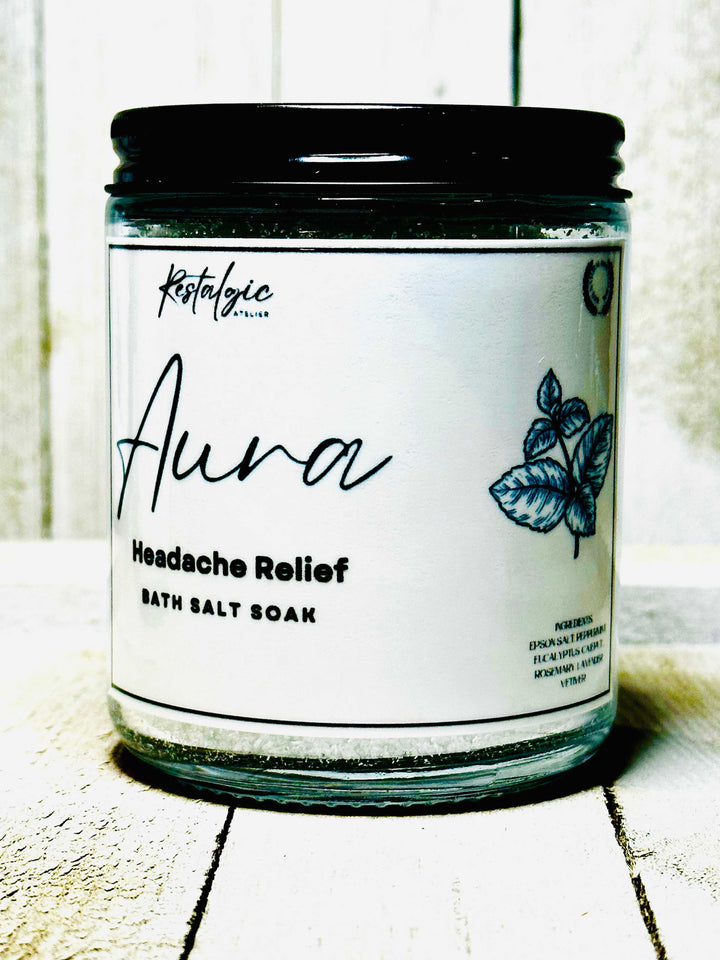 Aura headache relief bath salt soak jar with label on a dark lid