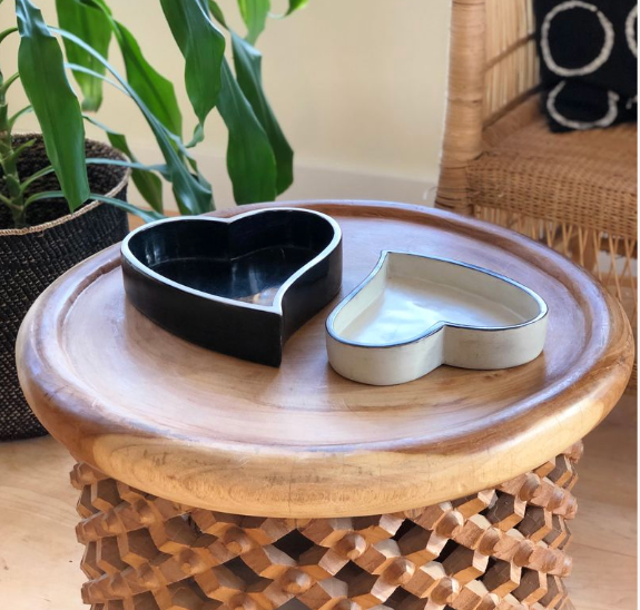 Two heart-shaped bowls, black and white, nested together with contrasting rims