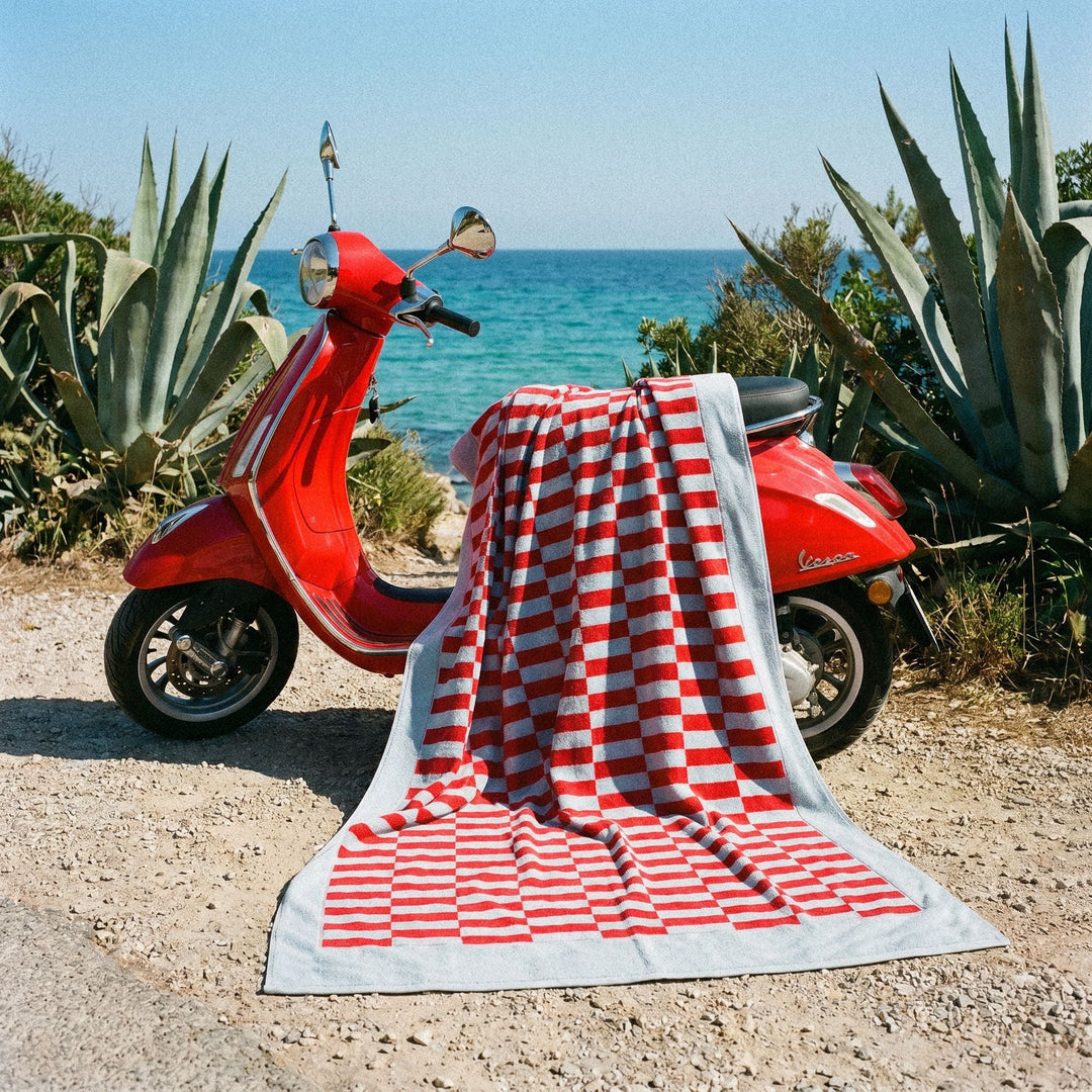 Red and white checkered cotton beach towel draped over scooter seat area.