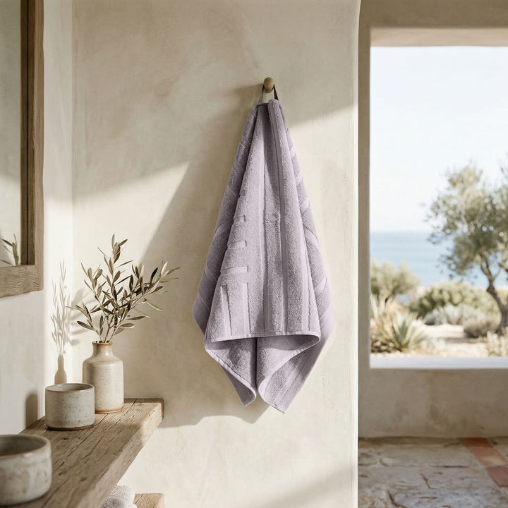 Lavender cotton towel hanging, striped terry texture with neatly folded edges.