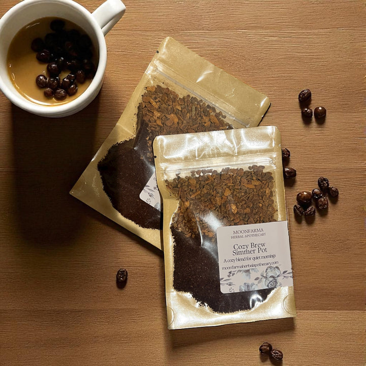 Simmer pot pouches with kraft paper packaging, dried tea blend on wooden table.
