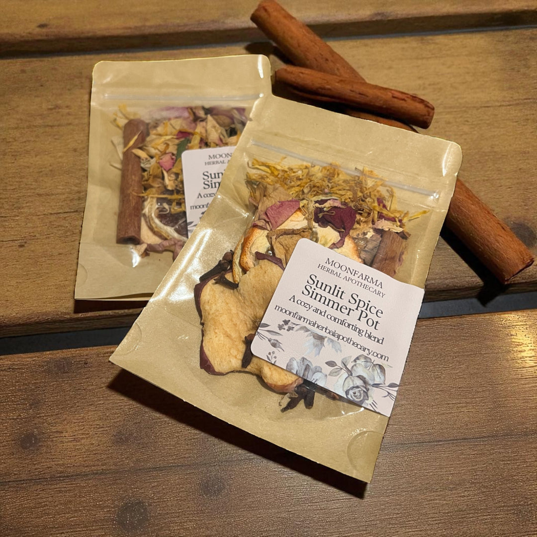 Kraft simmer pot pouches on wooden tray with cinnamon sticks, dried scent blend inside.