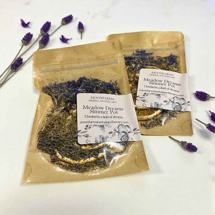 Two kraft simmer pot pouches with floral labels, dried herb mix and lavender sprigs.