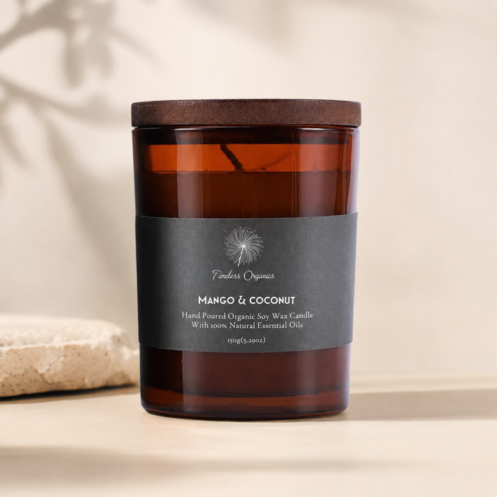 Amber glass Mango &amp; Coconut candle jar with black label and dark wood lid