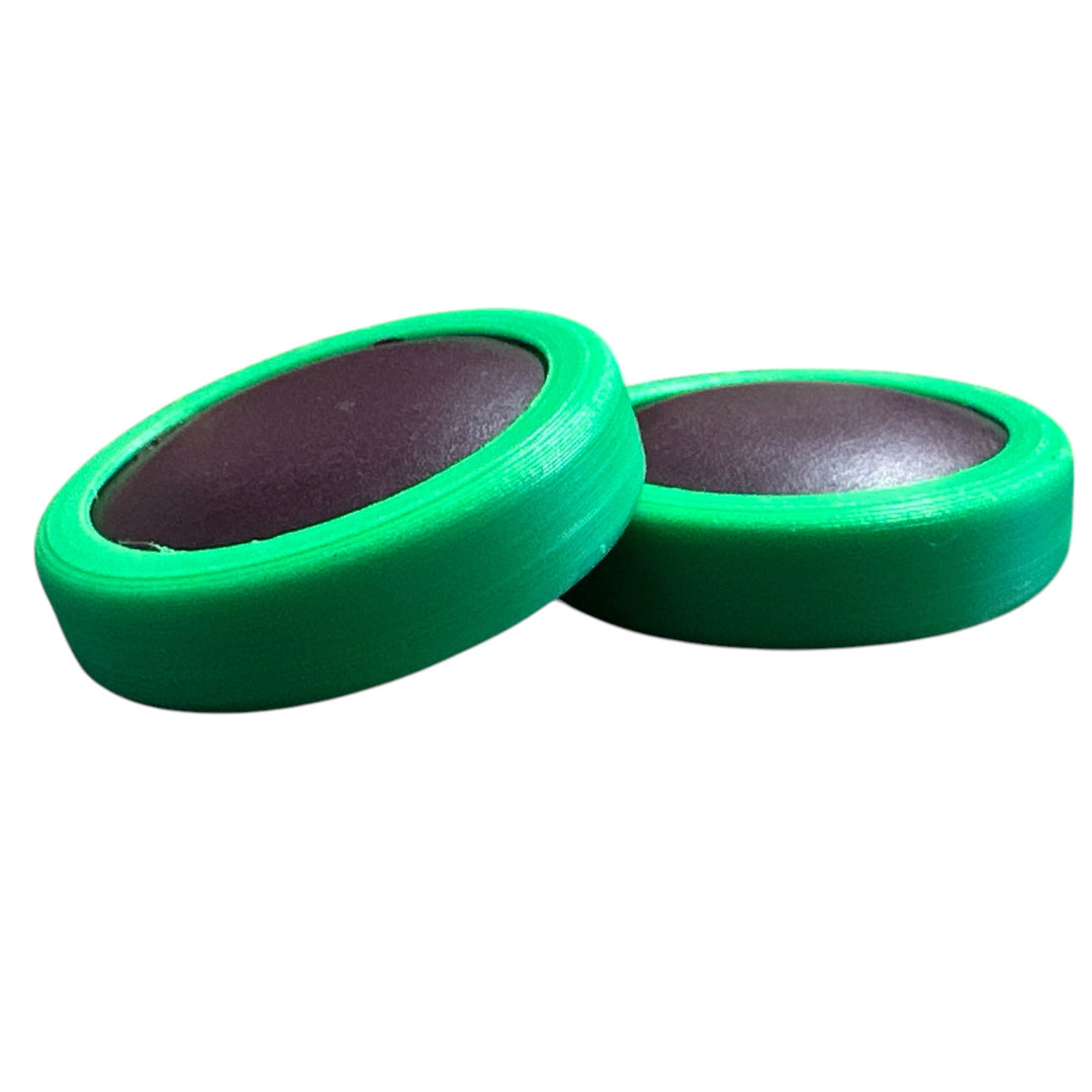 Green fidget moon toy with dark oval center, two stacked rings