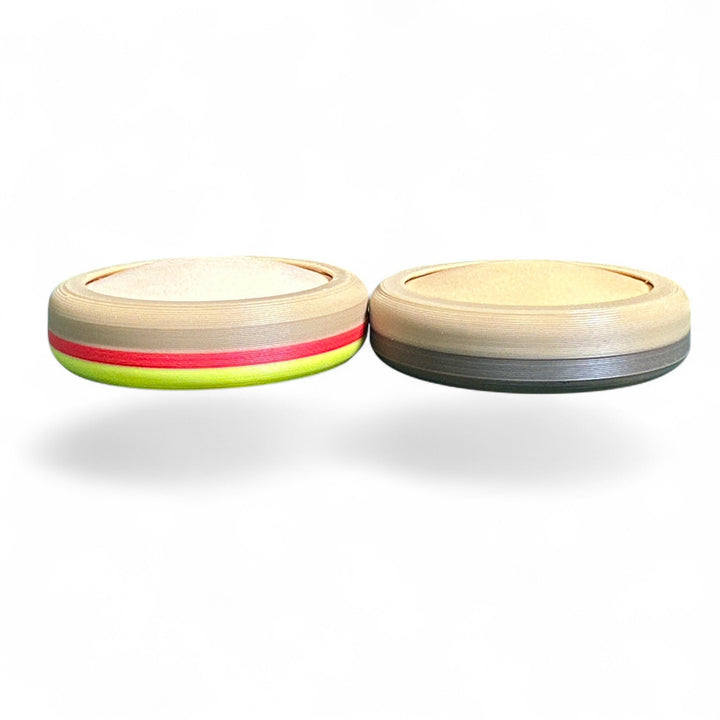 Two small round striped toy pieces, tan with red and green accents