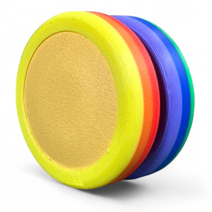 Rainbow pride ring with yellow, blue, and red bands, tan inner oval.