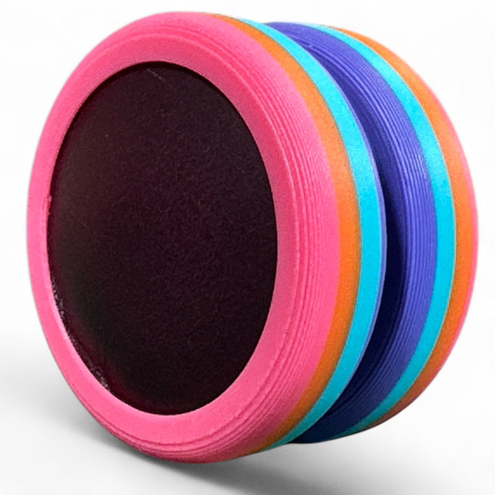 Pride Moons stacked disc with pink outer stripe, rainbow layers, and a dark center